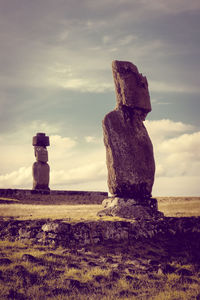 Stack of rocks on field against sky