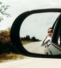 Reflection of woman in side-view mirror