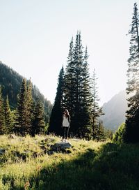 Man standing by tree on field against sky