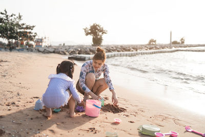 Side view of woman sitting at beach