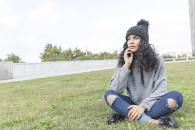 Full length of young woman sitting outdoors