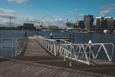 Wooden pier on lake against cloudy sky at victoria harbor