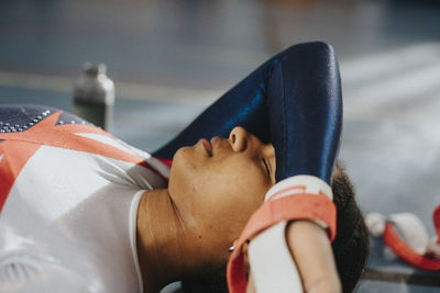 Female athlete resting on floor of gym