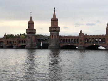 Arch bridge over river against buildings in city