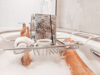 Reflection of man in bathtub at home