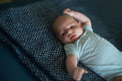 High angle view of baby boy lying on bed at home