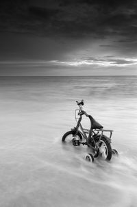 Bicycles on beach against sky