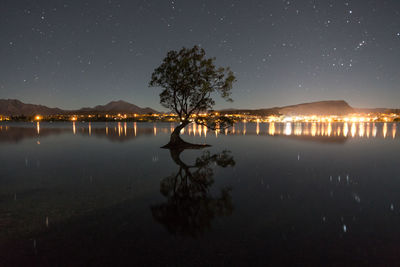 Scenic view of lake against sky at night