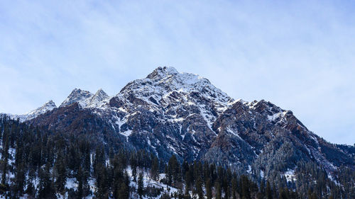 Low angle view of snowcapped mountain against sky