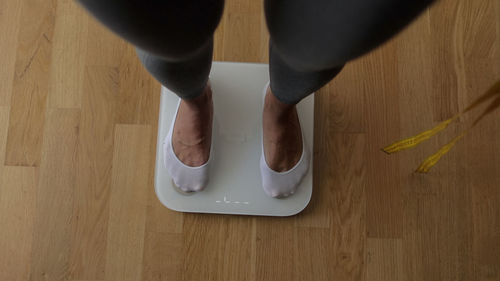 Low section of woman standing on table