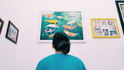 Rear view of woman standing against wall