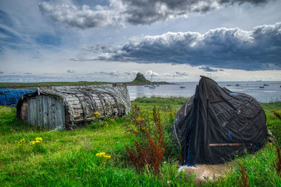 Wooden posts on field against sky
