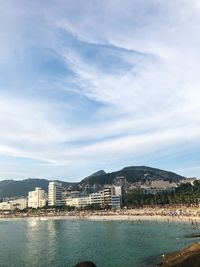 Sea by buildings against sky in city