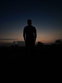 Silhouette man standing against sky during sunset