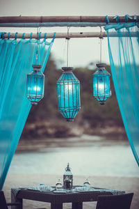 Illuminated lanterns below table at beach