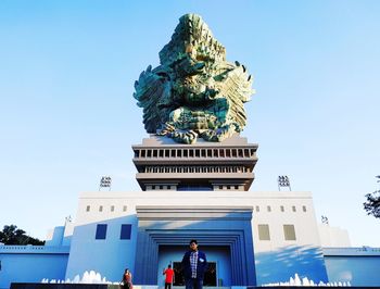 Low angle view of statue against buildings