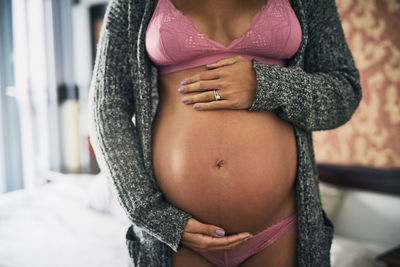 Midsection of woman standing at home