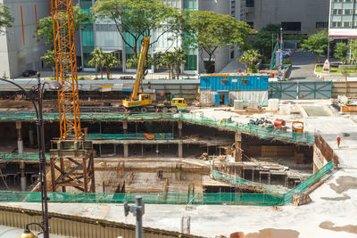 Construction site by swimming pool against buildings in city