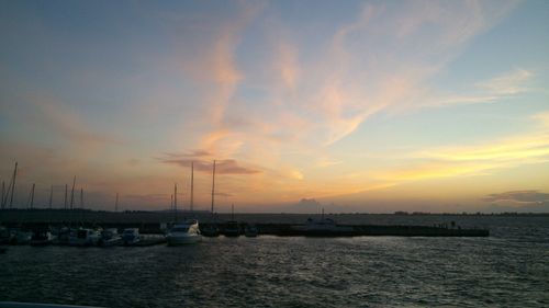 Sailboats in sea against sky during sunset