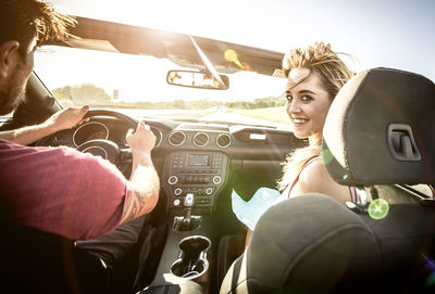 Woman sitting in car on sunny day