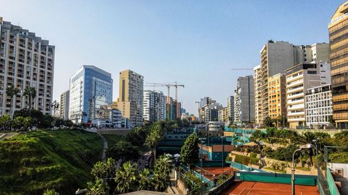 Buildings in city against clear sky