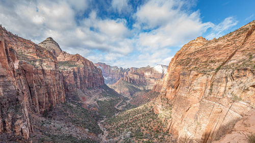 Rock formations on landscape against cloudy sky