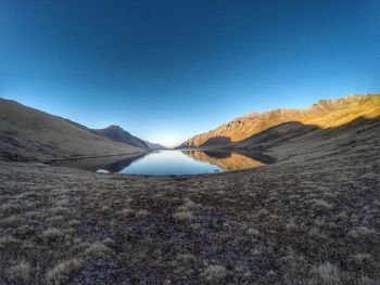 Scenic view of lake surrounded by mountain