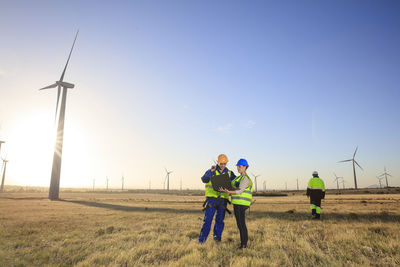 Three engineers with laptop on a wind farm
