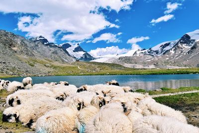 Scenic view of lake by mountains against sky