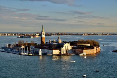 Boats in sea against buildings in city