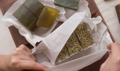 High angle view of person preparing food on paper