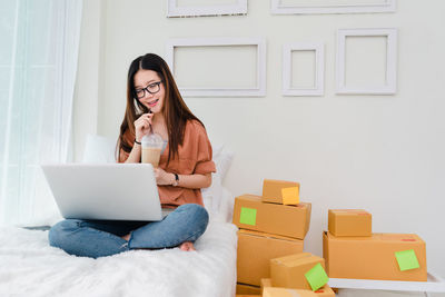 Young woman using mobile phone at home