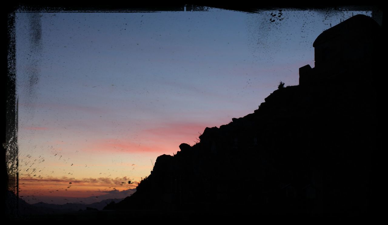 silhouette, sunset, sky, scenics, tranquility, tranquil scene, beauty in nature, rock - object, nature, transfer print, rock formation, built structure, dusk, architecture, sea, building exterior, auto post production filter, cliff, outdoors, clear sky