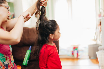 Side view of mother and girl at home