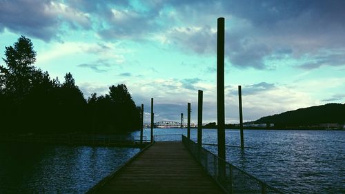 Pier on sea against cloudy sky