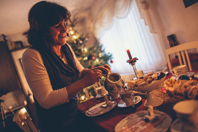 Woman eating food on table at home