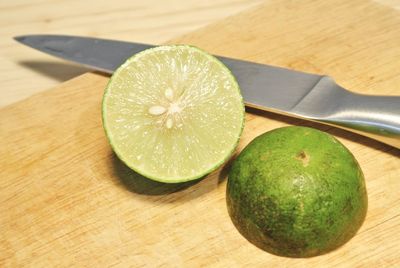 Close-up of lemons with knife on table