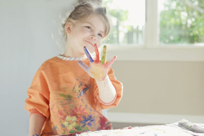 Young girl smiling with paint on her hand