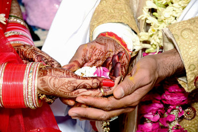 An indian bride and groom's hand being tied together before the wedding rituals