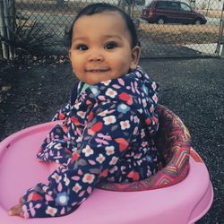 Portrait of smiling toddler standing in baby walker