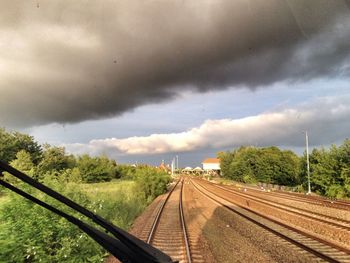 Railroad track against cloudy sky