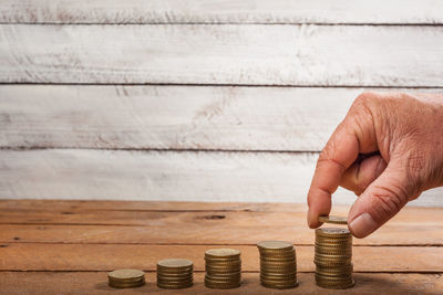 Close-up of a hand holding stack of wooden table