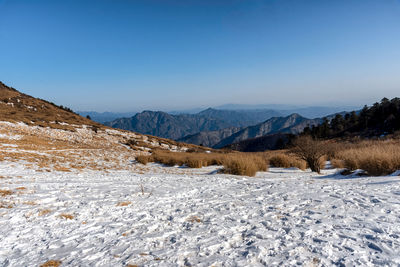 Scenic view of snowcapped mountains against clear blue sky