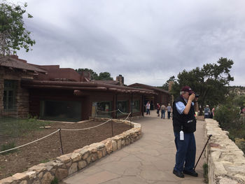 Man standing by built structure against sky