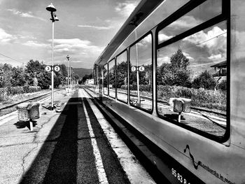 Street by trees against sky seen through glass window
