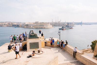 People at observation point by sea in city