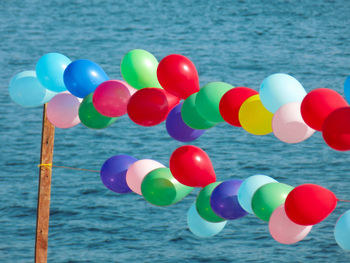 Close-up of multi colored balloons in sea