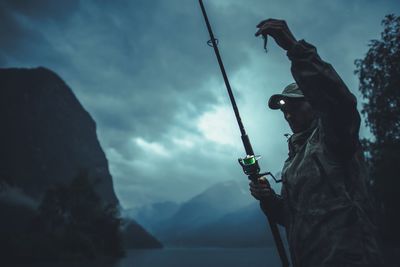 Man fishing in lake at dusk