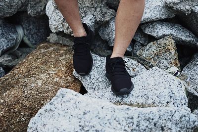 Low section of man sitting on rocks