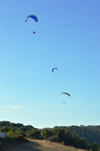 Low angle view of kite flying against clear blue sky
